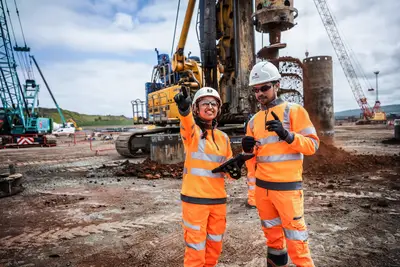 Frau und Mann arbeiten auf der Baustelle zusammen